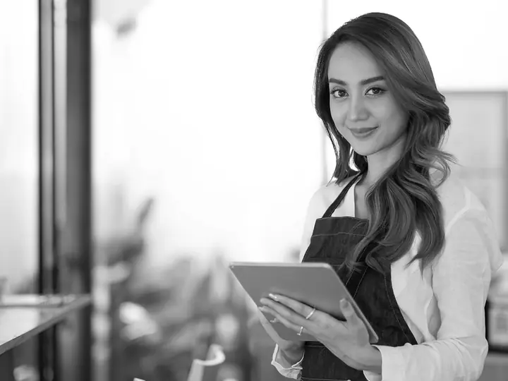 A shop owner at the counter of her own business